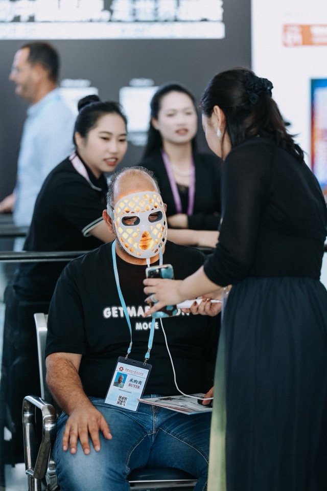 International buyer trying Radiant LED face mask at trade show