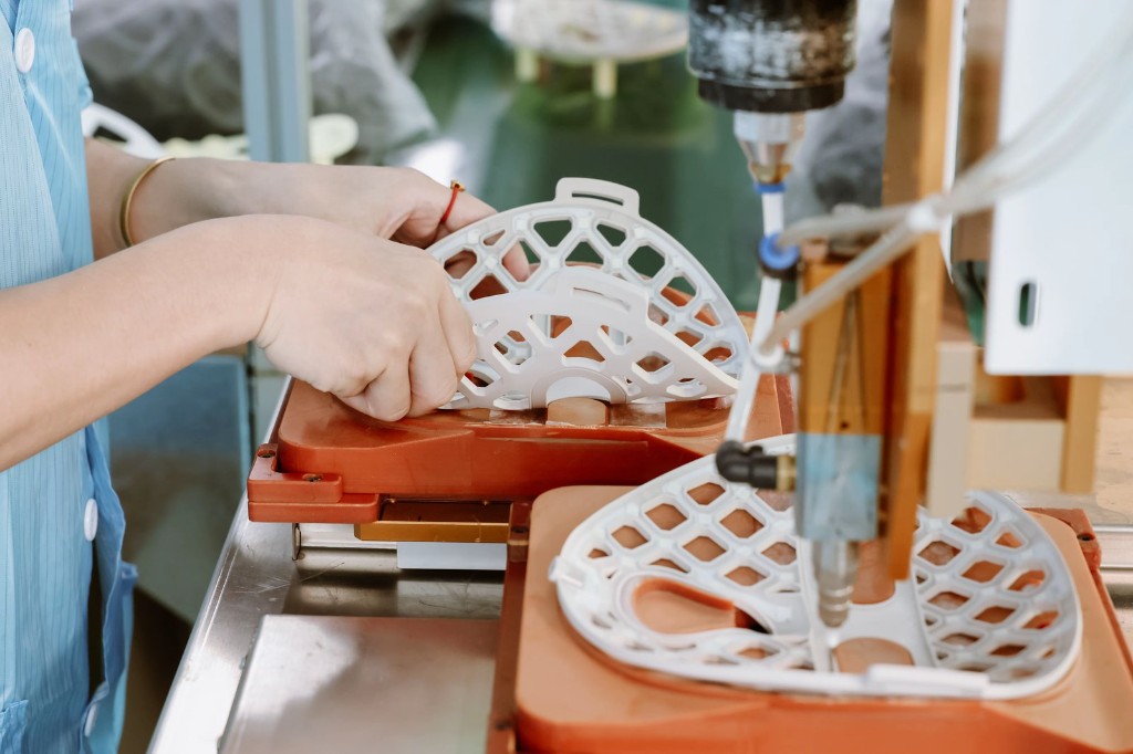Worker assembling LED face mask on production line